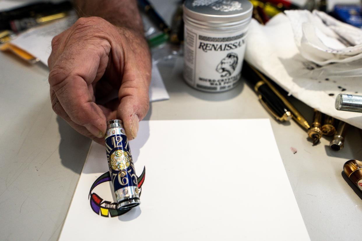 Robert Beers shows a finished cap for a pen he is making at his shop, Quill & Nib, in Valley Junction.