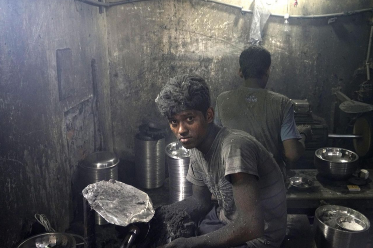 Arbeiten unter schwersten Bedingungen: dieser junge Mann aus Dhaka, Bangladesch, verbringt seine Tage mit dem Polieren von Pfannen in einer Aluminiumfabrik. (Bild: Abir Abdullah/EPA)