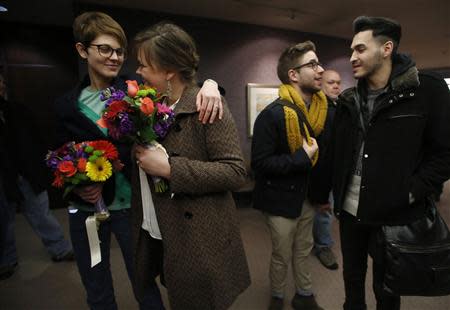Natalie Dicou (L) and her partner Nicole Christensen, and James Goodman (2nd R) and his partner Jeffrey Gomez (R), wait to get married at the Salt Lake County Clerks office in Salt Lake City, Utah, December 20, 2013. REUTERS/Jim Urquhart