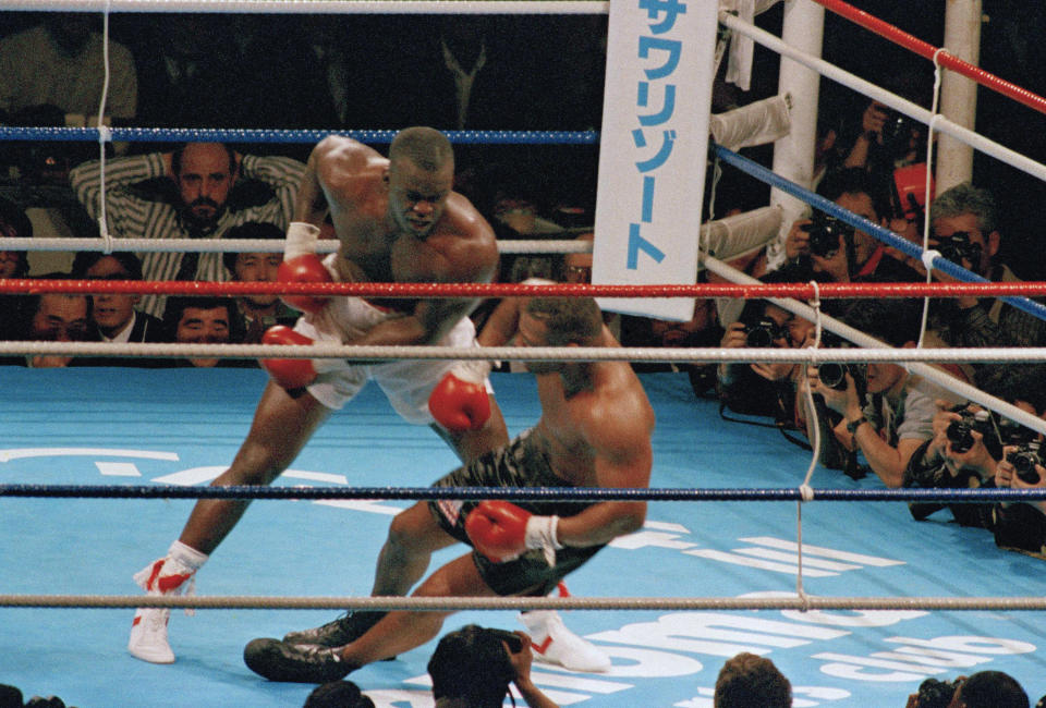 FILE - In this Feb. 11, 1990, file photo, James Douglas, left, follows with a left, dropping Mike Tyson to the canvas in the 10th round of scheduled 12-round heavyweight champion bout at the Tokyo Dome in Tokyo. In one of the more spectacular upsets in sports history, Douglas defeated Tyson, the reigning world heavyweight champion. (AP Photo/Tsugufumi Matsumoto, File)