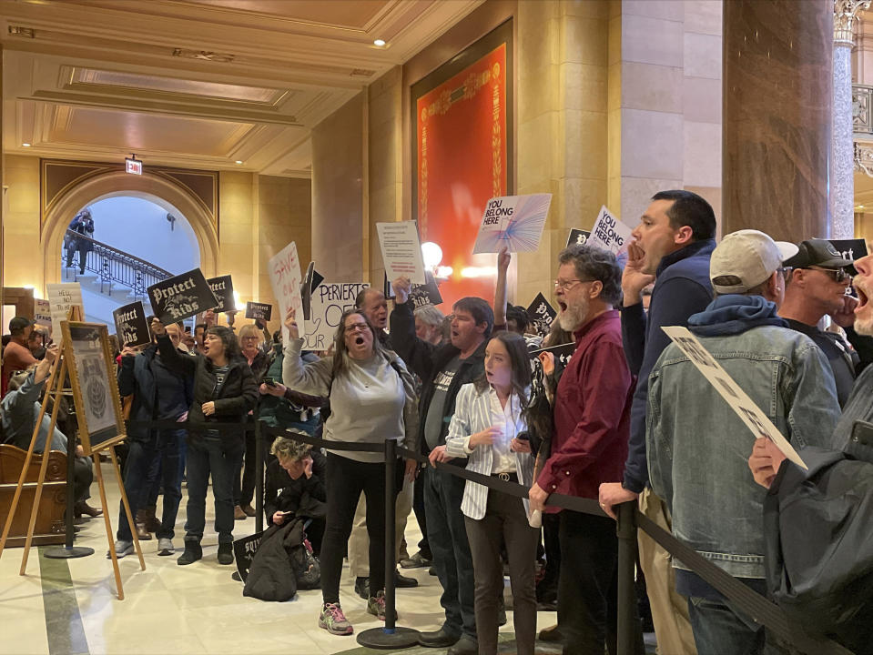 Dozens of protesters chanted for and against a bill that would make Minnesota a trans refuge state, bucking a national trend that's targeting nearly every facet of transgender existence, outside the room where lawmakers would vote on the bill at the state capitol, Thursday, March 23, 2023, in St. Paul, Minn. (AP Photo/Trisha Ahmed)