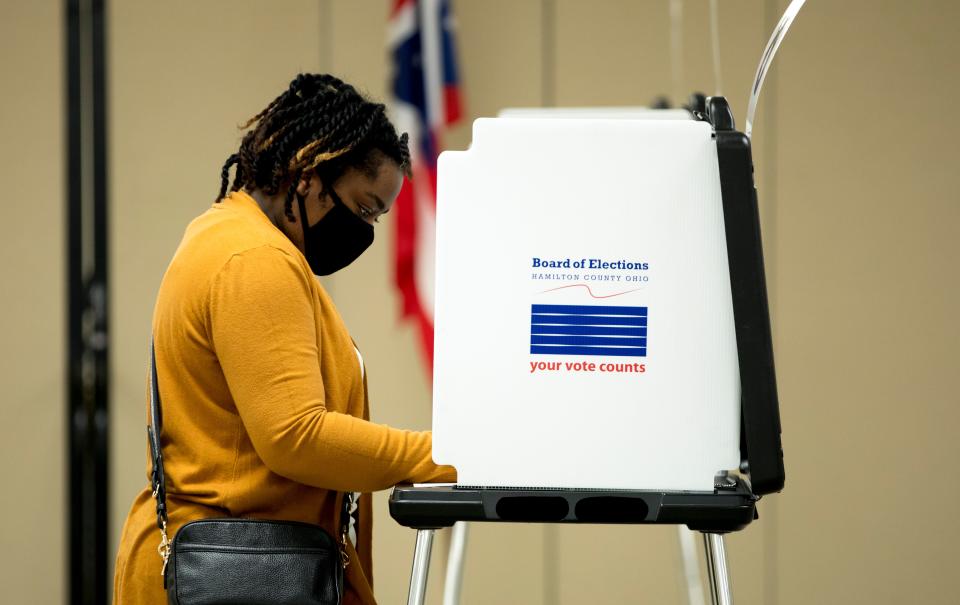 A person wears a mask to protect against the coronavirus,  votes in the Ohio primary election at the Hamilton County Board of Elections on Tuesday, April 28, 2020, in Norwood, a suburb of Cincinnati.