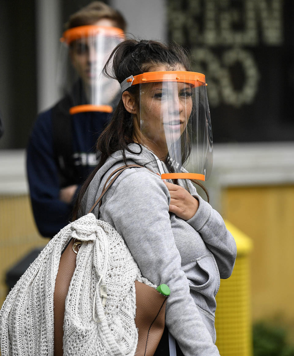 Students try out a new face shield to fight the coronavirus pandemic at a school in Cologne, Germany, Monday, May 25, 2020. The local manufacturer of plastic plain bearings IGUS produces and donates about 140,000 face shields for all students in the city. The effective protection of the easy to assemble shield was tested before at the school in Cologne by pupils, when face masks became mandatory. (AP Photo/Martin Meissner)