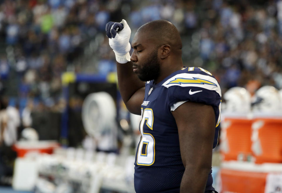 Los Angeles Chargers offensive tackle Russell Okung raises his fist during the playing of the national anthem before the team's NFL preseason football game against the Seattle Seahawks on Saturday, Aug. 18, 2018, in Carson, Calif. (AP Photo/Gregory Bull)