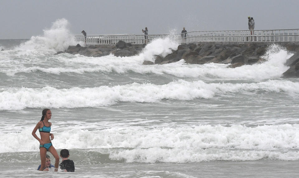 Children enjoy the surf in Ponce Inlet, Florida while waves crash on the jetty at Lighthouse Point Park on August 2, 2020. / Credit: Paul Hennessy/NurPhoto via Getty Images