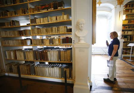 A visitor watches books at the Duchess Anna Amalia Library in Weimar August 15, 2014. REUTERS/Ralph Orlowski