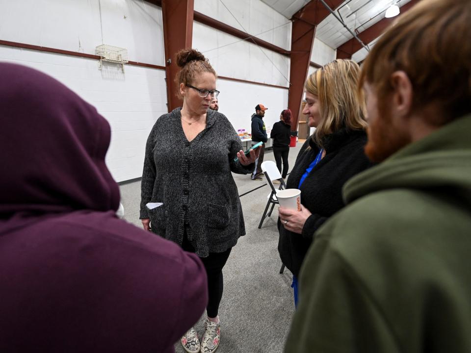 Jamie Cozza of East Palestine shares a cell phone video of a news conference with fellow evacuees at an assistance center, following a train derailment that forced people to evacuate from their homes, in New Waterford, Ohio.