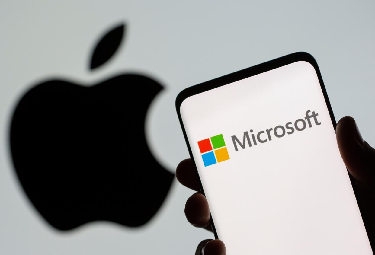 Microsoft logo is seen on the smartphone in front of displayed Apple logo in this illustration taken. Photo: Getty.