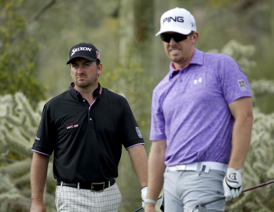 Graeme McDowell, of Northern Ireland, left, and Hunter Mahan look down the 17th hole during the third round of the Match Play Championship golf tournament on Friday, Feb. 21, 2014, in Marana, Ariz. (AP Photo/Ted S. Warren)