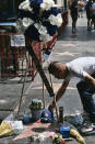 Jesus Carcamo leaves a Dodgers baseball cap at the star of Los Angeles Dodgers broadcaster Vin Scully along the Hollywood Walk of Fame in the Hollywood section of Los Angeles on Wednesday, Aug, 3, 2022. The Hall of Fame broadcaster, whose dulcet tones provided the soundtrack of summer while entertaining and informing Dodgers fans in Brooklyn and Los Angeles for 67 years, died Tuesday night. He was 94. (AP Photo/Richard Vogel)