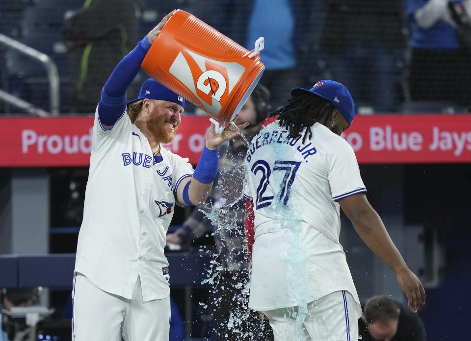 Toronto Blue Jays' Justin Turner (2) douses Vladimir Guerrero Jr. (27) after defeating the New York Yankees in a baseball game in Toronto on Tuesday, April 16, 2024. (Nathan Denette/The Canadian Press via AP)