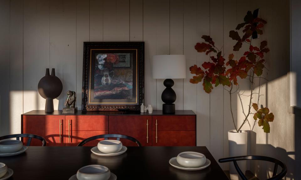 In the dining area of the barn’s nave, Felix-Ashman placed an iron-framed leather credenza from Croft House, decorated with a black ash “gourd” lamp by Scott McGlasson, a black stoneware sculpture by Heather Rosenman, and a still-life painting that belonged to the clients.