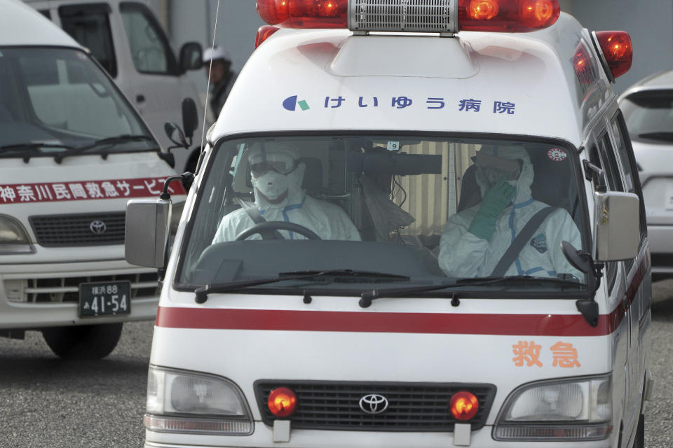 Officials in protective suits drive an ambulance near the cruise ship Diamond Princess anchored at the Yokohama Port in Yokohama, near Tokyo Friday, Feb. 7, 2020. Japan on Friday reported 41 new cases of a virus on a cruise ship that's been quarantined in Yokohama harbor while the death toll in mainland China rose to 636, including a doctor who got in trouble with authorities in the communist country for sounding an early warning about the disease threat. (AP Photo/Eugene Hoshiko)