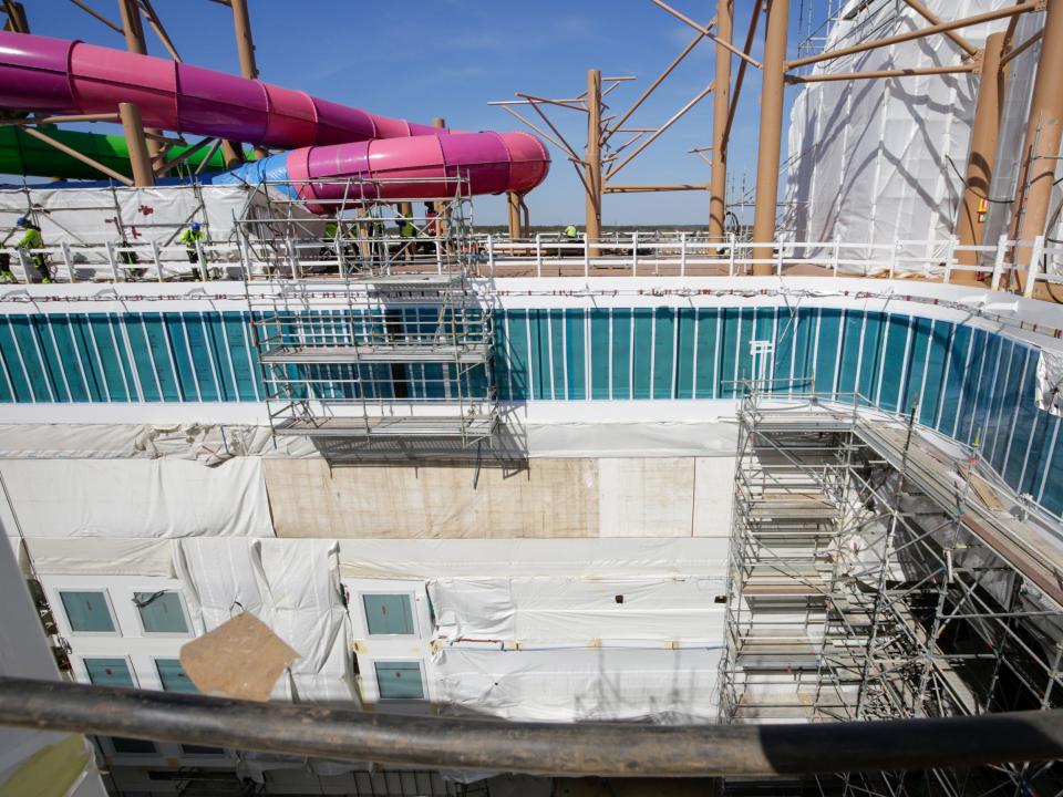 The Thrill Island neighborhood with water slides under scaffolding and tarps while it's being constructed on Royal Caribbean's Icon of the seas