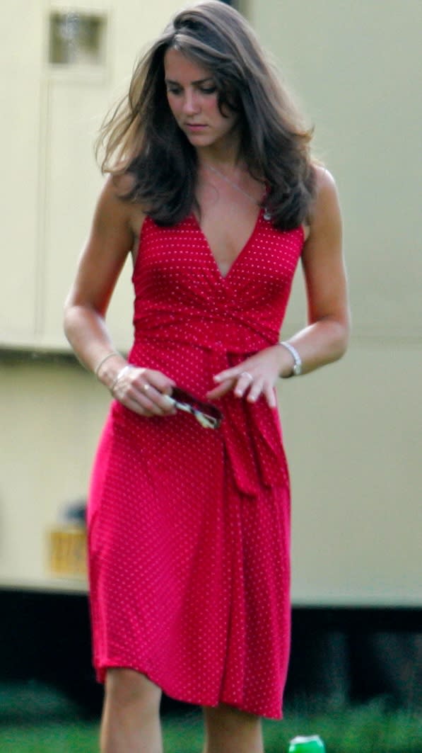 Kate Middleton walks across grass as she attends the Chakravarty Cup charity polo match