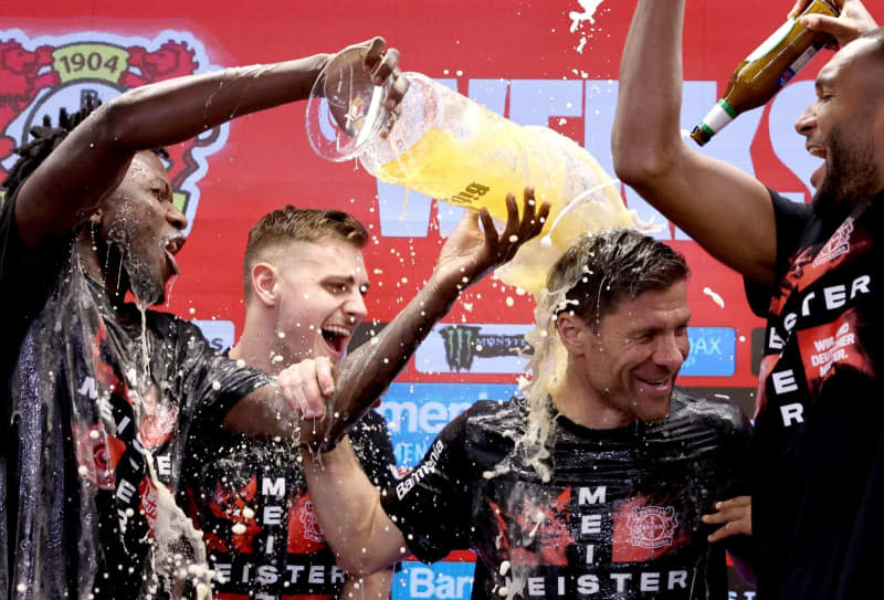 Leverkusen coach Xabi Alonso (C) is showered with beer by his players at the post-match press conference following the German Bundesliga soccer match between Bayer 04 Leverkusen and SV Werder Bremen at BayArena. Rolf Vennenbernd/dpa