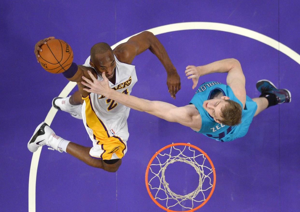 Los Angeles Lakers guard Kobe Bryant, left, puts up a shot as Charlotte Hornets center Cody Zeller defends during the first half of an NBA basketball game, Sunday, Nov. 9, 2014, in Los Angeles. The Lakers won 107-92. (AP Photo/Mark J. Terrill)