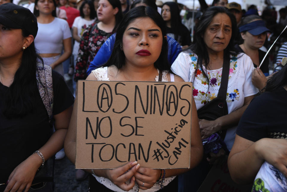 Una mujer sostiene un cartel con la frase "Los niños no se tocan", durante una manifestación por el secuestro y asesinato de una niña de 8 años, en la principal plaza de Taxco, México, el 28 de marzo de 2024. (AP Foto/Fernando Llano)