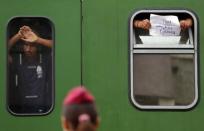 Police guard a train full of refugees stuck in a stalemate as they refuse to obey law enforcement officers and get off at the station, fearing they would be put up in a nearby refugee camp in Bicske, Hungary, September 4, 2015. REUTERS/Laszlo Balogh