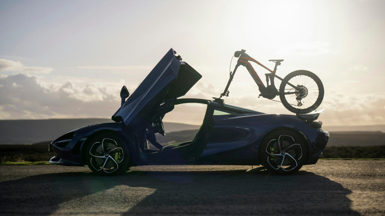  McLaren e-MTB mounted to the top of a McLaren sports car. 