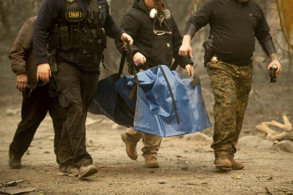 FILE - In this Wednesday, Nov. 14, 2018 file photo, sheriff's deputies recover the body of a Camp Fire victim in Paradise, Calif. The body count from California's deadliest wildfire is back down to 85 after authorities determined that a bone fragment previously classified as "unidentified" belongs to a victim named back in January. The Butte County Sheriff's office said Wednesday, Sept. 25 2019 that the number of unidentified victims from the November 2018 Camp Fire now stands at one (AP Photo/Noah Berger, File)