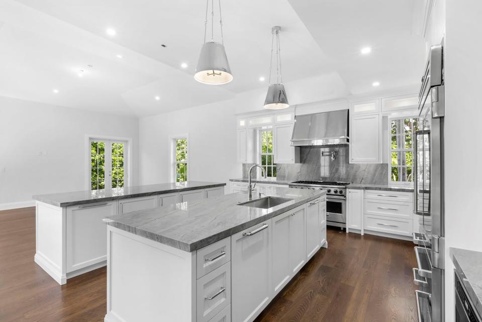 The contemporary-style kitchen in a new Palm Beach house at 130 Algoma Road has hardwood floors, marble counters and stainless-steel appliances.