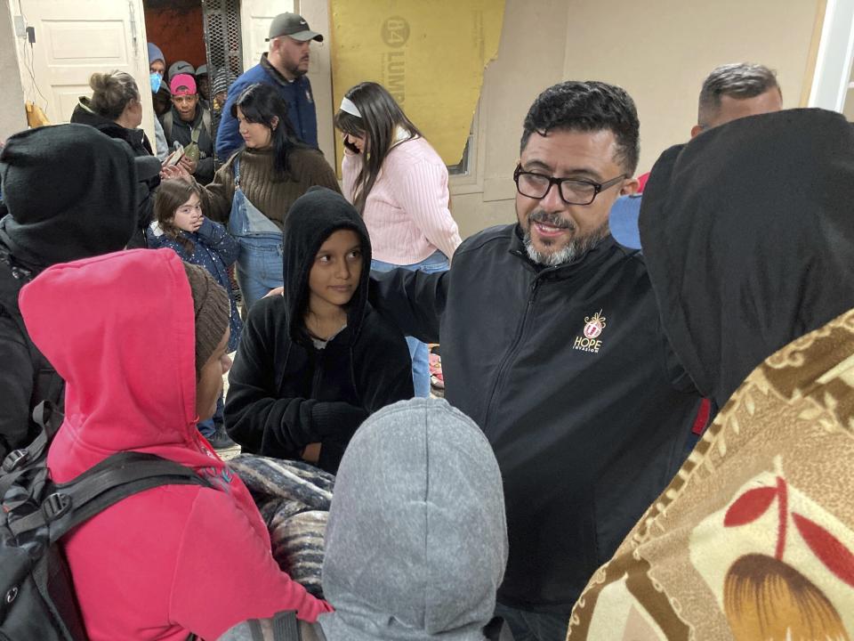 Pastor Elias Rodriguez of Casa Nueva Voz, right, greets immigrants as they seek refuge from winter weather in a shelter near the U.S. border in Ciudad Juárez, Mexico, on Thursday, Dec. 22, 2022. Hundreds of migrants are gathered in unusually frigid cold temperatures along the Mexican-U.S. border near El Paso, Texas, awaiting a U.S. Supreme Court decision on whether and when to lift pandemic-era restrictions that prevent many from seeking asylum.(AP Photo/Morgan Lee)