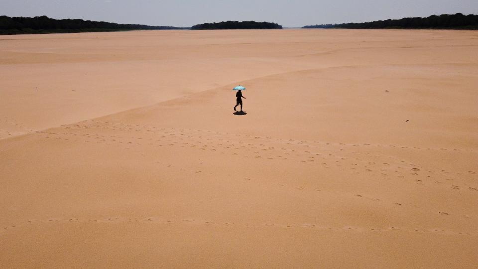 A man walks through a dry area in the Amazon due to drought