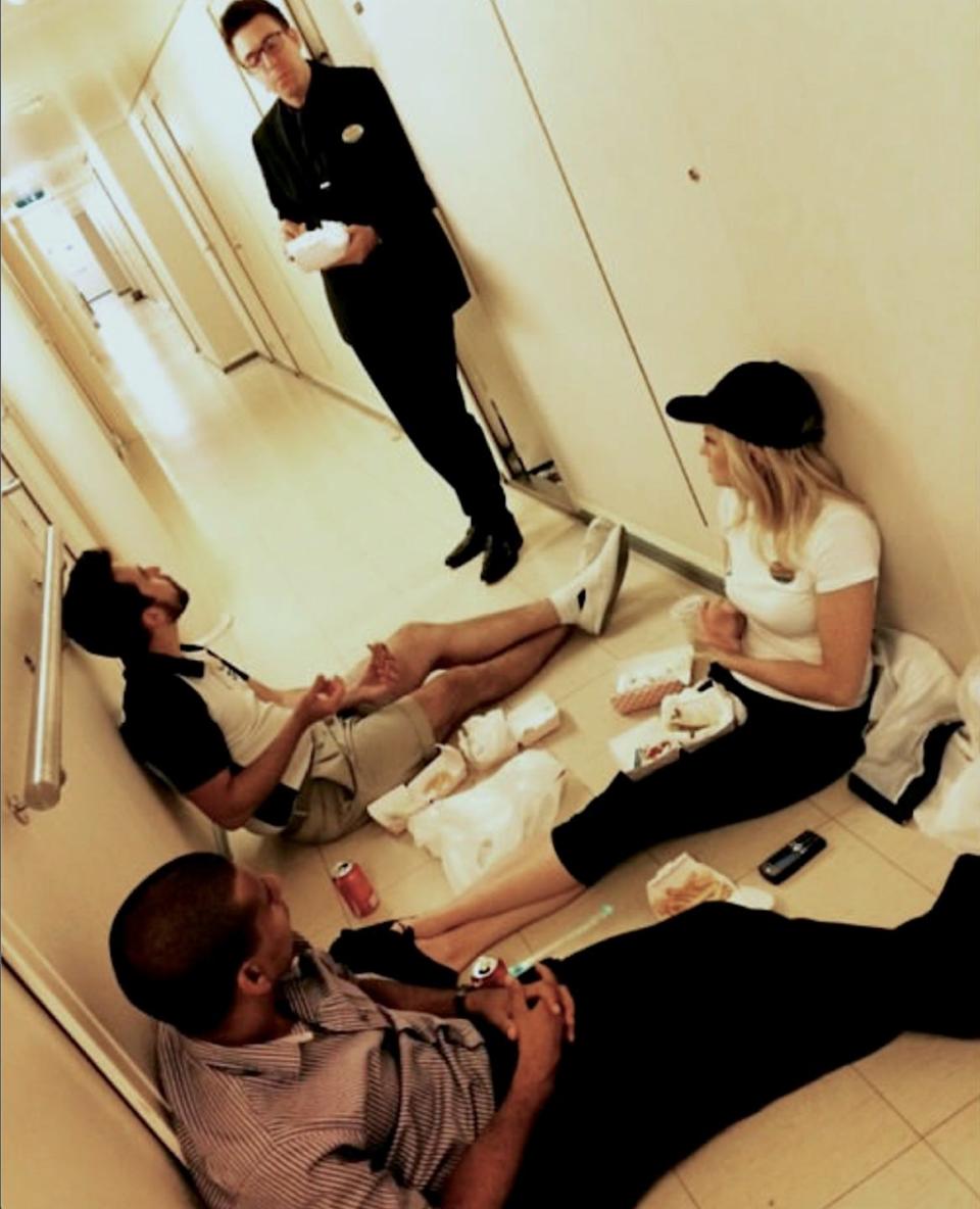 crew members sitting in a long, beige hallway and chatting