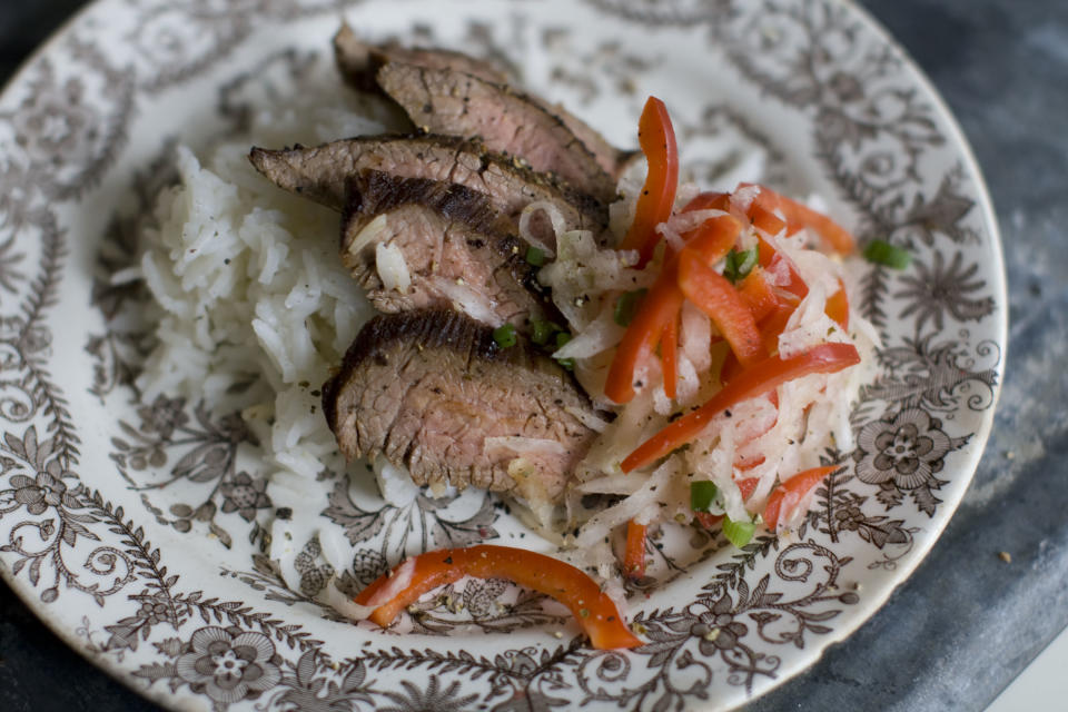 This Dec. 2, 2013 photo shows pan seared flank steak with daikon slaw in Concord, N.H. Daikon radish resemble giant white carrots, but have a mild peppery bite. (AP Photo/Matthew Mead)