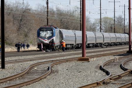 Emergency personnel examine the scene after an Amtrak passenger train struck a backhoe, killing two people, in Chester, Pennsylvania, April 3, 2016. REUTERS/Dominick Reuter