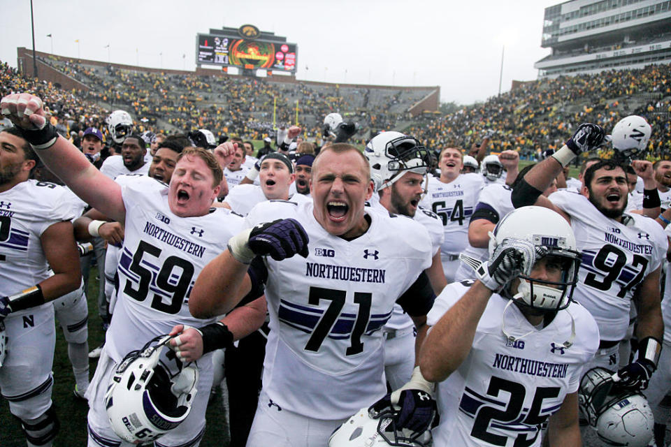 IOWA CITY, IOWA- OCTOBER 1: Offensive lineman J.B. Butler #59, offensive lineman Tommy Doles #71 and running back Corey Acker #25 of the Northwestern Wildcats sing their fight song. (Getty Images)