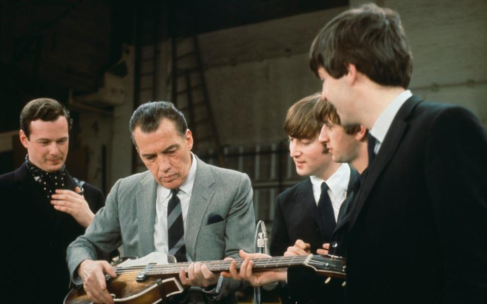 Ed Sullivan tries out Paul McCartney's Hofner violin bass during rehearsals for the show in 1964