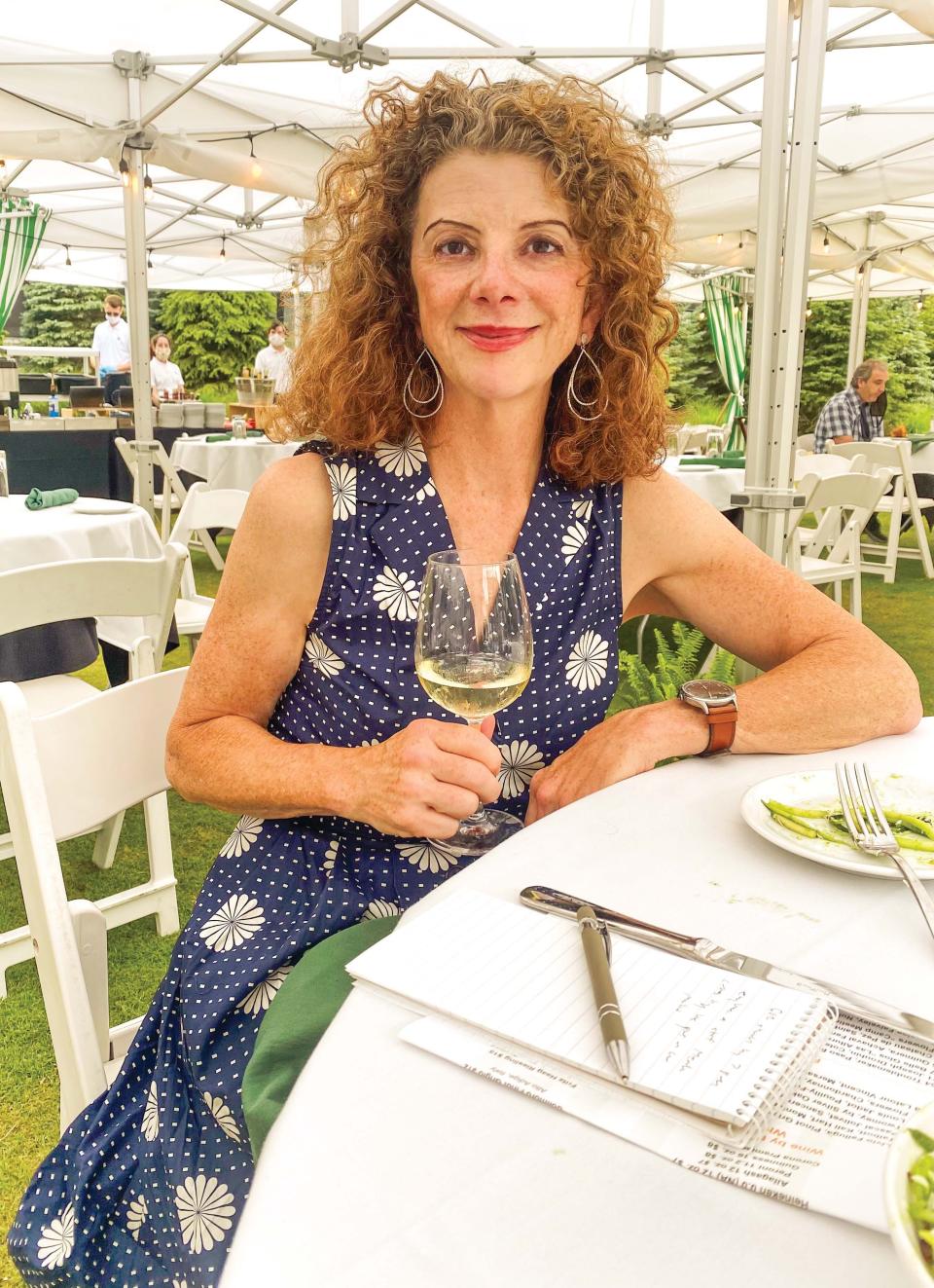 Lettie Teague dines alfresco with a glass of Chablis while making writing notes. (