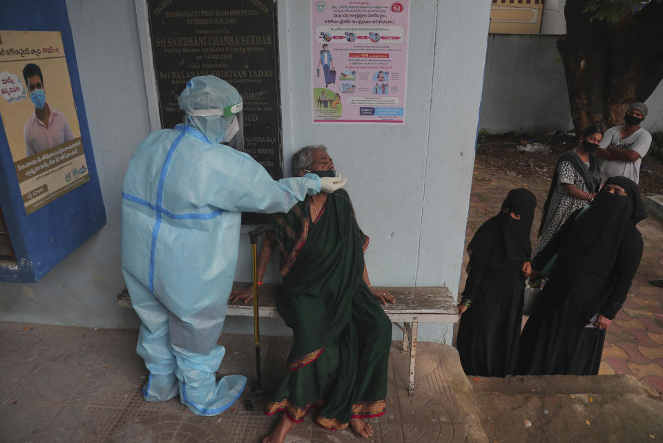 A health worker takes a nasal swab sample at a COVID-19 testing center in Hyderabad, India, Saturday, Oct. 3, 2020. India has crossed 100,000 confirmed COVID-19 deaths on Saturday, putting the country's toll at nearly 10% of the global fatalities and behind only the United States and Brazil. (AP Photo/Mahesh Kumar A.)