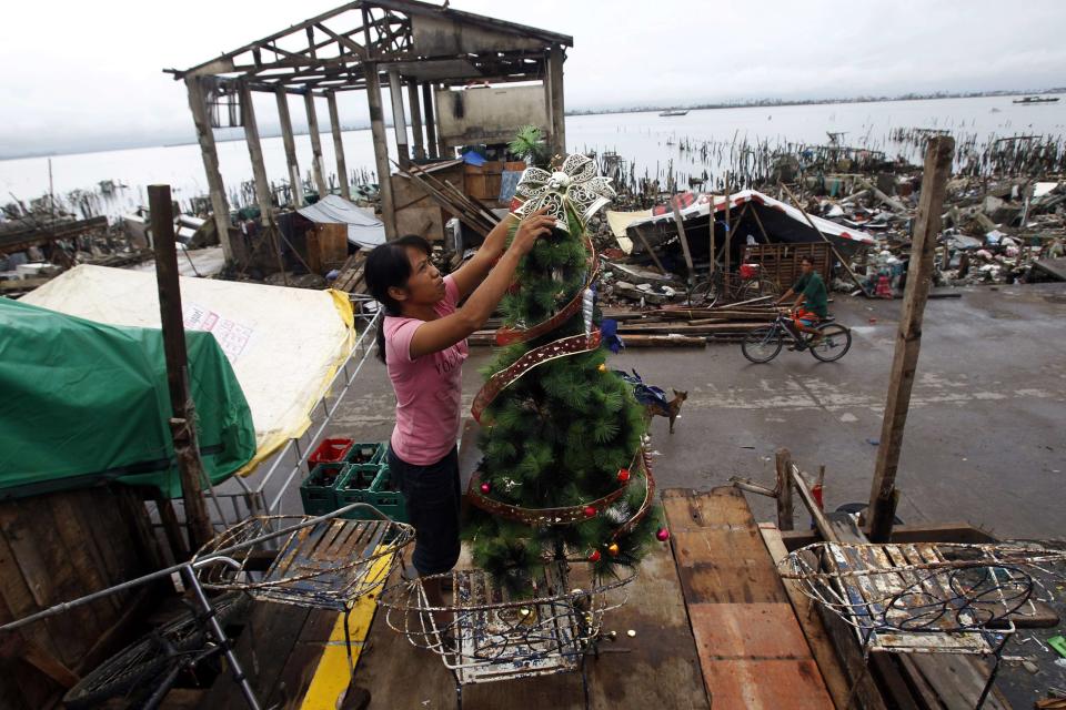 Nora Yara, a victim of super typhoon Haiyan, decorates a Christmas tree along a devastated area of Sagkahan town, Tacloban city, central Philippines