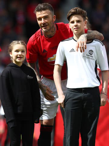 <p>Matthew Lewis/Getty</p> David Beckham with his children Harper and Cruz during the Manchester United '99 Legends and FC Bayern Legends match in 2019