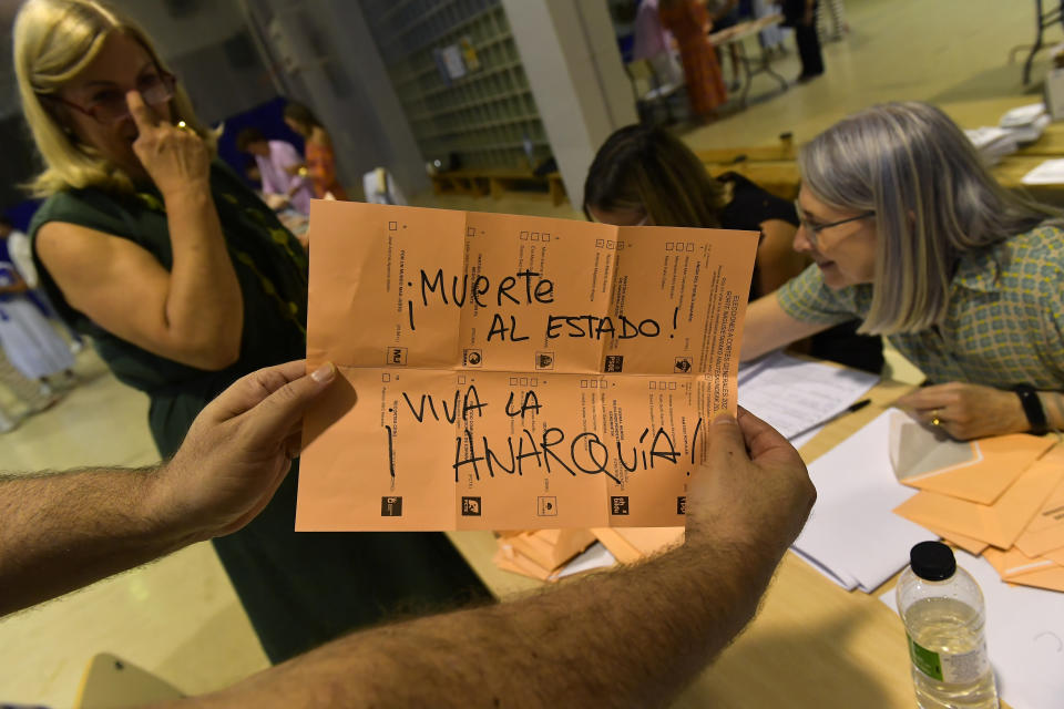 An election official shows an invalid ballot that reads in Spanish "death to the state, long live anarchy" as ballots are counted at a polling station in Pamplona, northern Spain, Sunday July 23, 2023. Spain is holding general elections, that could make the country the latest European Union member to swing to the political right, at the height of summer, when millions of citizens are likely to be vacationing away from their regular polling places.(AP Photo/Alvaro Barrientos)