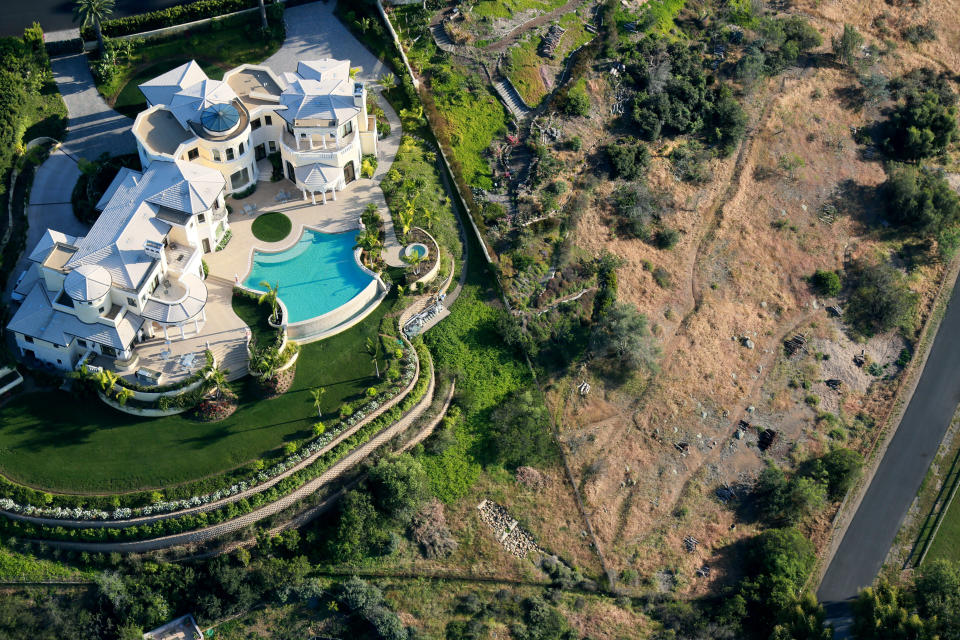 A home with a pool and well-watered garden next to landscape dried out by drought in San Diego. (Photo: Sandy Huffaker via Getty Images)