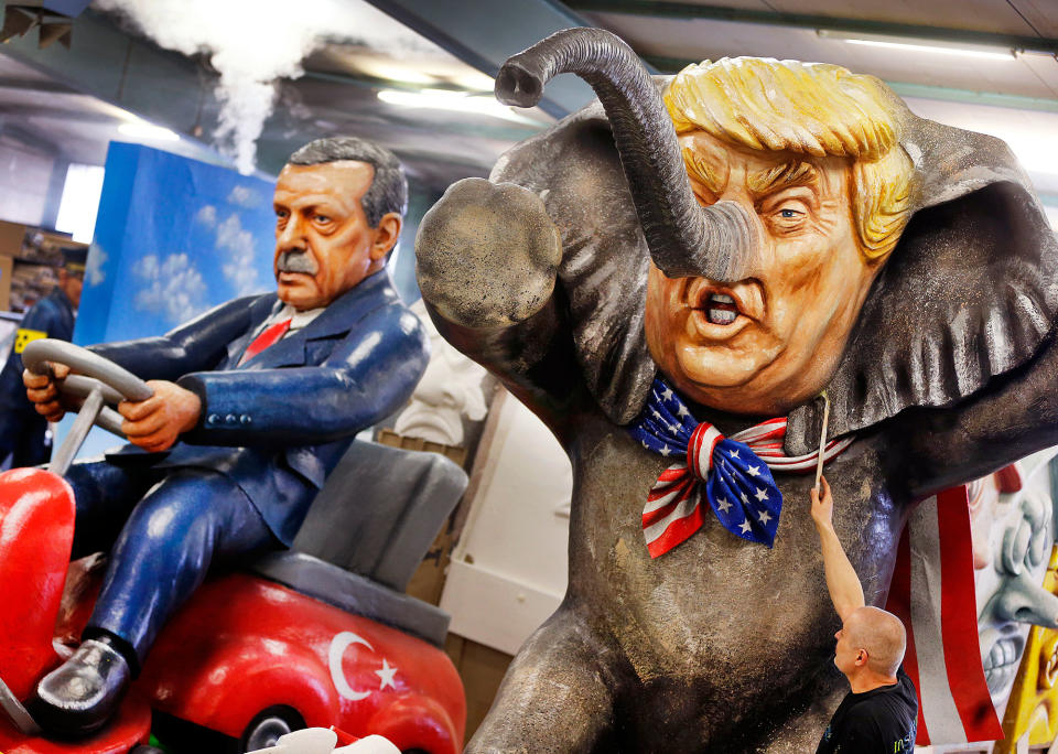 <p>A worker poses with a brush in front of a figure depicting US President Donald Trump as an elephant and Turkish President Erdogan sitting on a bobby car during a press preview in a hall of the Main carnival club in Mainz, Germany, Tuesday, Feb. 21, 2017. The figure is part of various carnival floats of the Rose Monday procession in Mainz. (AP Photo/Michael Probst) </p>