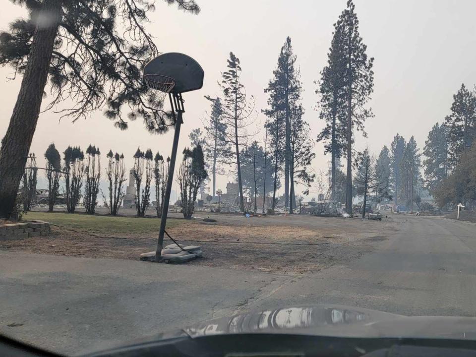 A view of a residential road in Medical lake with burned debris and smoke-filled air.