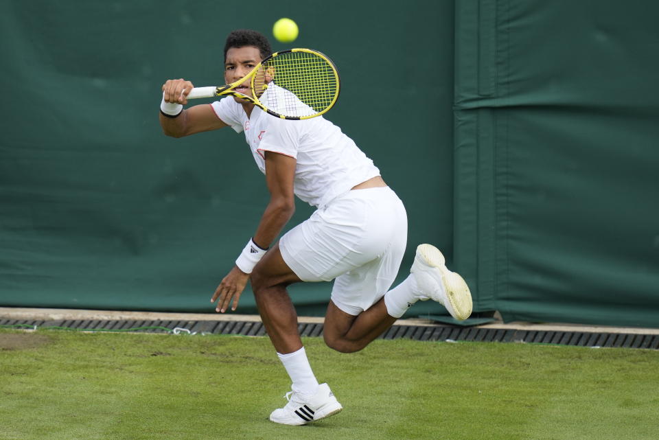 Canada's Felix Auger-Aliassime plays a return to Brazil's Thiago Monteiro during the men's singles first round match against on day three of the Wimbledon Tennis Championships in London, Wednesday June 30, 2021. (AP Photo/Kirsty Wigglesworth)