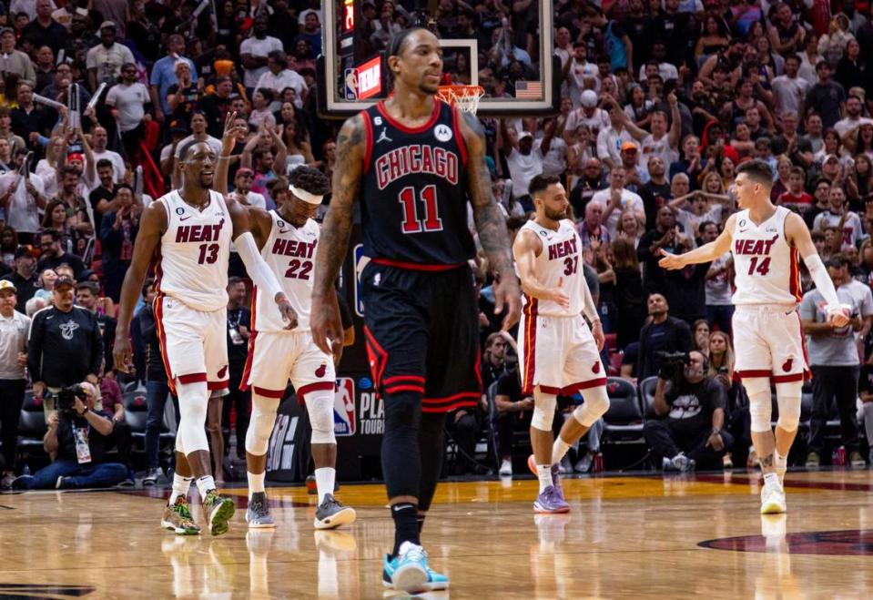 Miami Heat players celebrate as Chicago Bulls forward DeMar DeRozan (11) reacts in the foreground during the fourth quarter of an NBA play-in tournament game at Kaseya Center in Downtown Miami, Florida, on Friday, April 14, 2023.