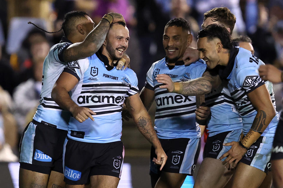 Braydon Trindall of the Sharks celebrates with teammates after scoring a try.