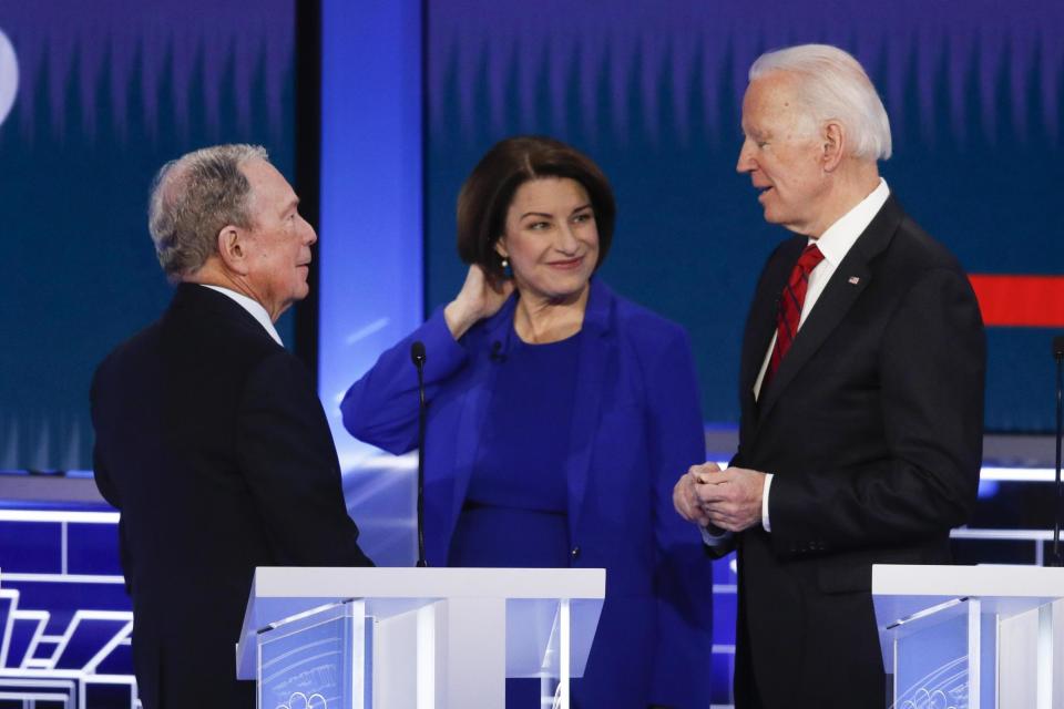 Mike Bloomberg, Amy Klobuchar and Joe Biden talk during a break in a Democratic presidential primary debate (AP)