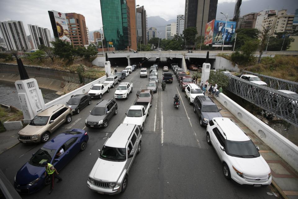 ARCHIVO - En esta foto de archivo del 29 de mayo de 2020 se observa a vehículos en fila cerca de una gasolinería para intentar llenar sus tanques en medio de una escasez de combustible en Caracas, Venezuela. (AP Foto/Ariana Cubillos, Archivo)