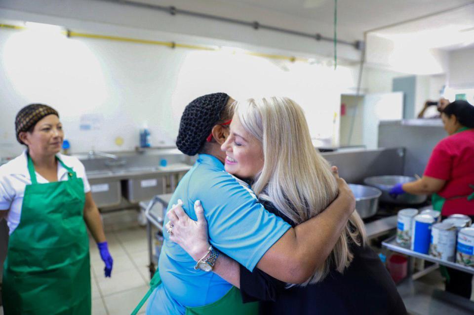 In this handout photo provided by the Governor's Office, Puerto Rico Gov. Wanda Vazquez embraces a cafeteria worker during a visit to the Ramon Marin Sola School, in Guaynabo, Puerto Rico, Monday, Aug. 12, 2019. Vazquez visited the elementary school she attended as a child, marking the beginning of the 2019-2020 school year. (Governor's Office via AP)