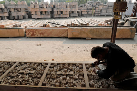 A worker engraves a stone that Hindu groups say will be used to build a Ram temple at a disputed religious site in Ayodhya in the northern state of Uttar Pradesh, India, November 6, 2018. Picture taken November 6, 2018. REUTERS/Pawan Kumar