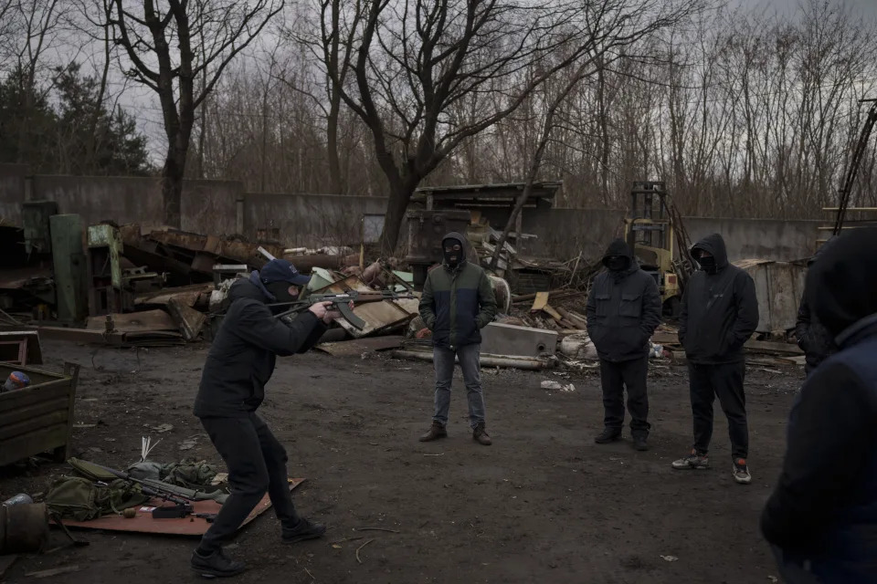 Roman, a former Ukrainian soldier injured in combat, gives instructions on how to handle weapons and move during conflict to civilians in the outskirts of Lviv, west Ukraine, Thursday, March 3, 2022. The group of friends with no combat experience decided to learn military skills to defend their country from invading Russian forces. (AP Photo/Felipe Dana)