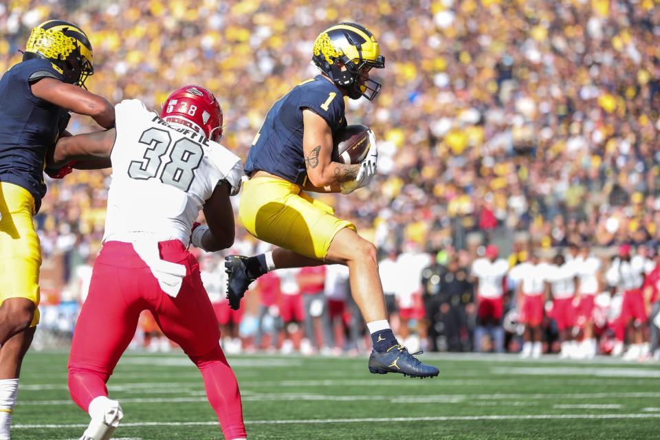 Michigan wide receiver Roman Wilson (1) jumps into the end zone for a touchdown against UNLV during the first half at Michigan Stadium in Ann Arbor on Saturday, Sept. 9, 2023.